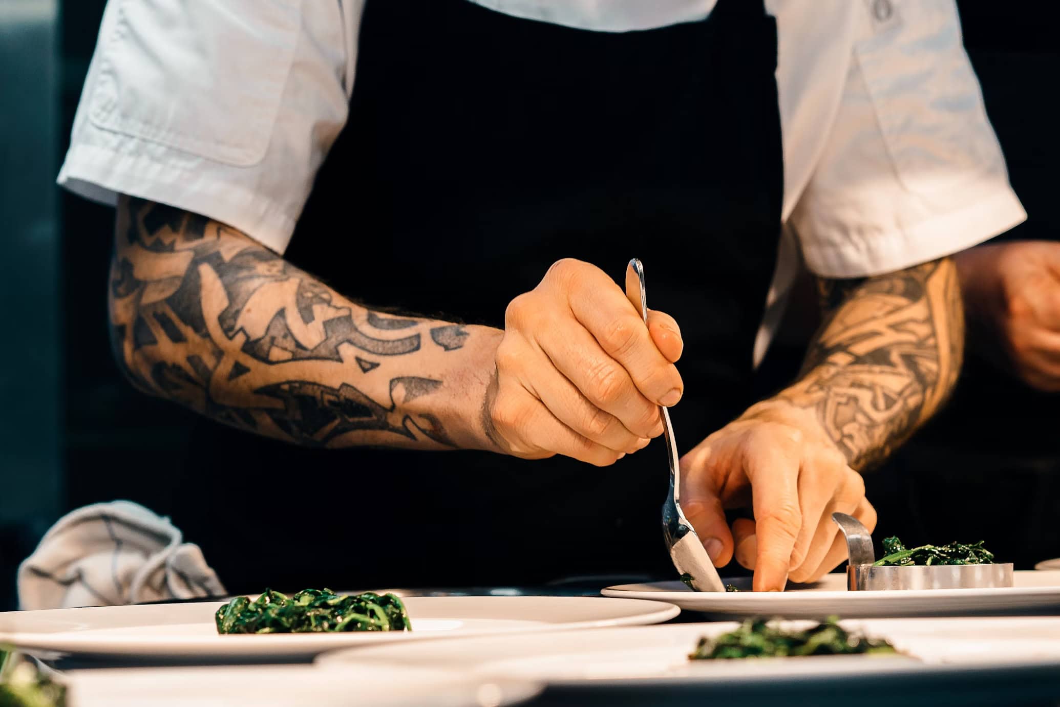 Young tattooed person learning how to become a chef