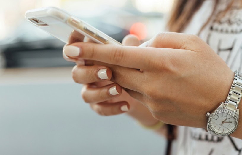 Mujer calculando su salario en el móvil para ver la diferencia entre bruto y neto