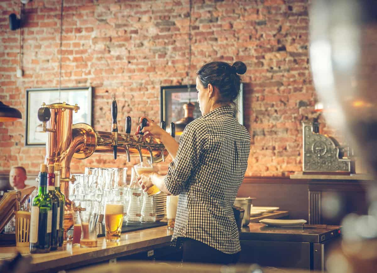 Professional bartender serving beer, showcasing bartender job description